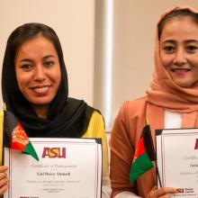 Two women hold certificates