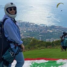Photo of a woman on top of a hill wearing a helmet
