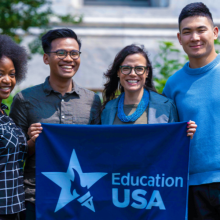 smiling young people hold EducationUSA banner