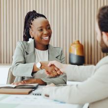 smiling businesswoman shaking hands with man