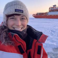 Scientists on an ice floe with a ship in the background