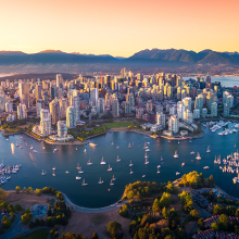 aerial photo of Vancouver surrounded by water and mountains in the background