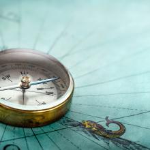 brass compass on old map