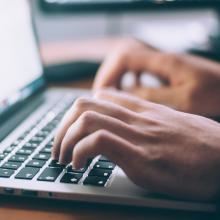hands typing on a laptop