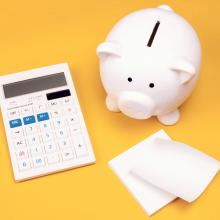 piggy bank and calculator against yellow background