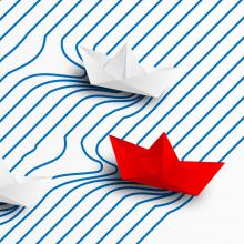 colored paper boats on a striped background
