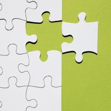 one puzzle piece to the side of partially finished puzzle