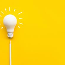 A white lightbulb on a yellow background