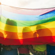 Photo of a group of students holding a pride flag.
