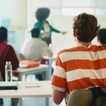 Photo of a student facing the front of a classroom.