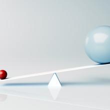 seesaw with large grey ball on one side and small red ball on other