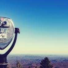 Photo of a binocular viewer looking over a landscape