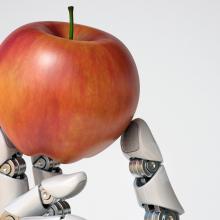 Robot hand holding an apple