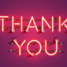 neon "Thank You" sign on purple background